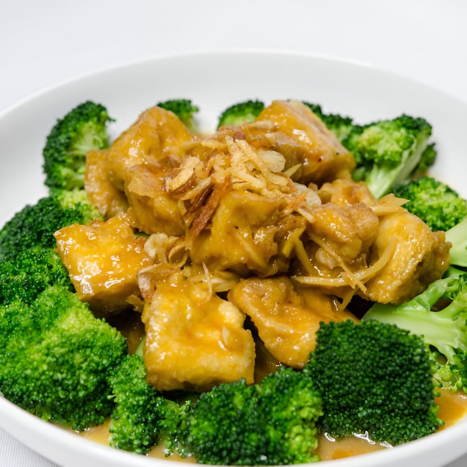 Manow Thai's golden tofu and broccoli in a rich sauce, topped with crispy fried onions.